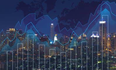 Trading graph on the cityscape at night and world map background