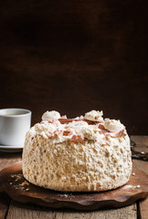 Meringue cake and a cup of coffee, vintage wooden background, se