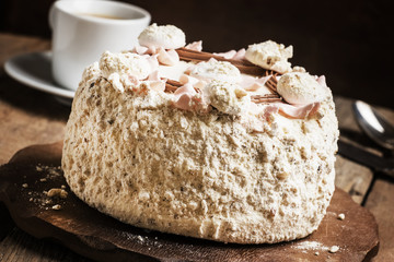 Meringue cake and a cup of coffee, vintage wooden background, se