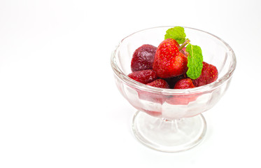 Few strawberries in glass cup isolated on white