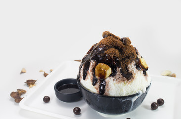 Chocolate shaved ice serve with whipped cream and banana