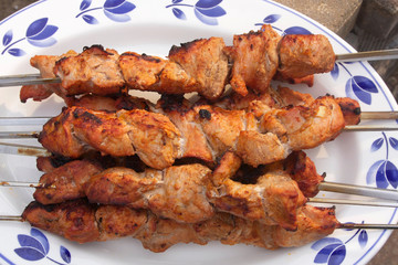 Grilled meat on skewers.Fresh grilled pork pieces on skewers close up ready for outdoor party.