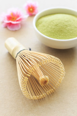 Matcha fine powdered green tea on paper texture with warm fall colors, soft-focus in the background. over light