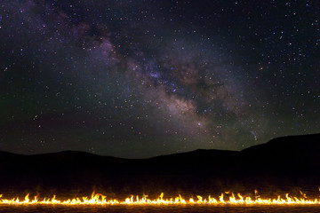 Line of Burning Fire in the desert with milky way