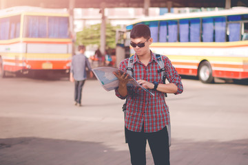 Young man standing looking map,Backpack Exploring Destination Ca