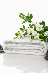 Fototapeta na wymiar gardenia on towel with black stones 