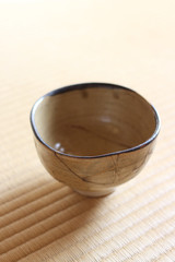 金継された抹茶の茶碗が日本の畳の上に置いてある