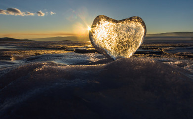 Icy heart in the waves in the light of sunset. lake Baikal