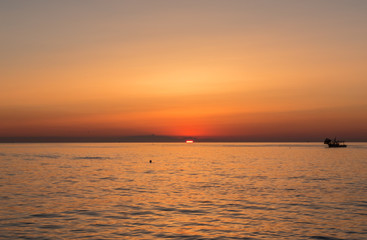 Fishing boats pull their nets at the sunrise. Adriatic cost. Emilia Romagna. Italy.