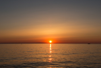 Fototapeta na wymiar Fiery sunrise at Italian beach. Summer season. Emilia Romagna region. Adriatic sea. Italy