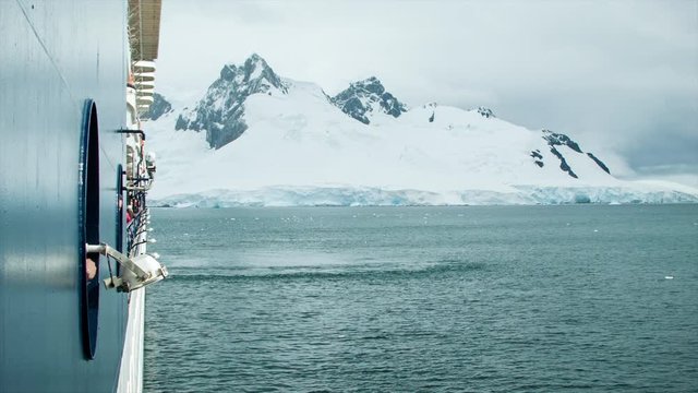 Cruise Ship in Antarctica with Passengers Viewing the Frozen landscape from the Side of the Boat
