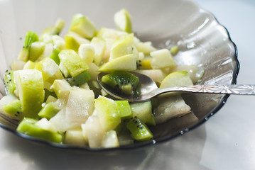 Fruit salad with slices of KIWI,Apple and pear on a black plate