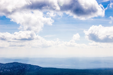 Obraz premium Blue mountains and clouds above view from airplane.High mountain landscape in haze