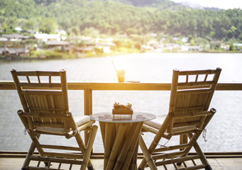 Fototapeta premium Relaxing wooden desk on wood terrace against beautiful view
