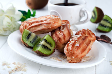 Tasty eclairs on table