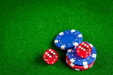 poker chips and dice on green background top view