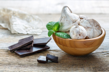 Meringue with dark chocolate and a sprig of mint.