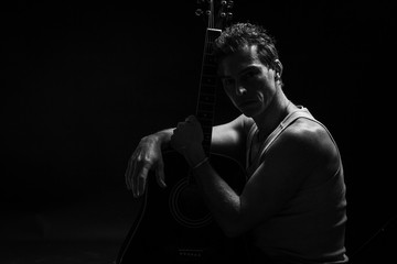 Low key portrait of man with his guitar