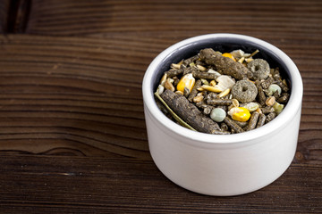 dry food for rodents in bowl wooden background