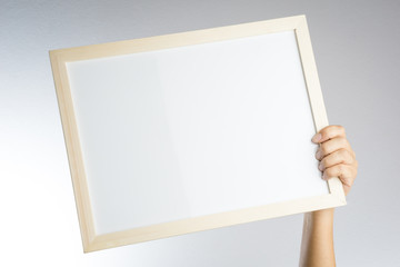 Hand holding blank wooden frame