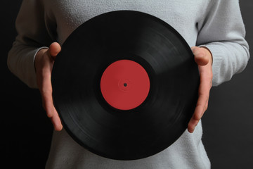 Men's hands holding a vinyl record in his hand, close-up.