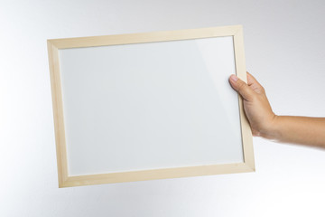 Hand holding blank wooden frame
