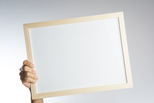 Hand holding blank wooden frame