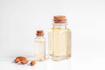 cosmetic almond oil in glass bottle on white background