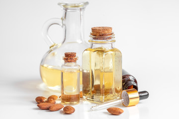 cosmetic almond oil in glass bottle on white background