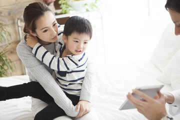 Pediatrician physician is showing tablet to mother and child