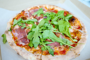 Pizza with parma ham and rockets  in takeaway box
