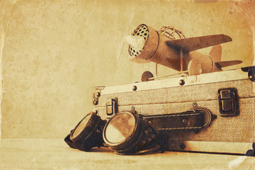 vintage toy plane, pilot galsses and old suitcase