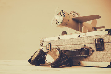 vintage toy plane, pilot galsses and old suitcase