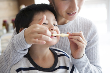 Mother is brushing her son's teeth