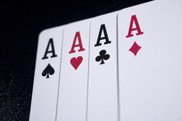 ace four of a kind poker card on dark black background