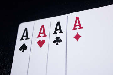 ace four of a kind poker card on dark black background