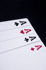 ace four of a kind poker card on dark black background