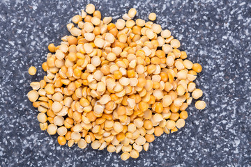 Yellow split peas isolated on a mottled grey blue background
