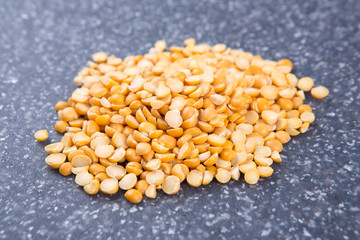 Yellow split peas isolated on a mottled grey blue background
