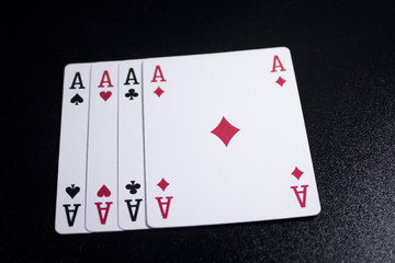 ace four of a kind poker card on dark black background