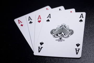 ace four of a kind poker card on dark black background