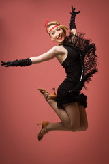 Fototapeta premium Ładna aktorka w czarnej sukience retro tańczy Charleston