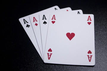 ace four of a kind poker card on dark black background