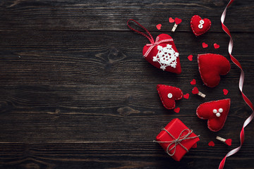 Background with red hearts and gift box on old dark wooden table