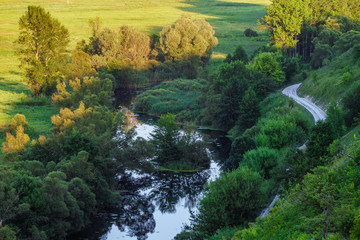 Wild river and winding road from a steep slope