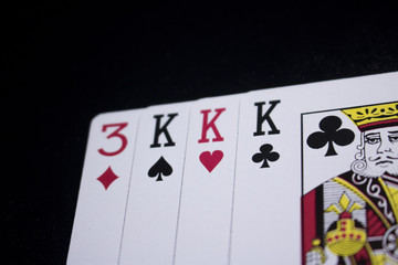 three of a kind poker card on dark black background