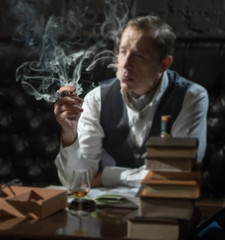 A man smokes a cigar and the smoke released from the mouth