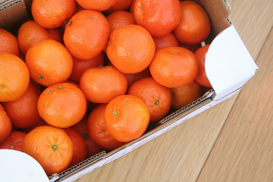 Mandarini in cassetta su tavolo di legno