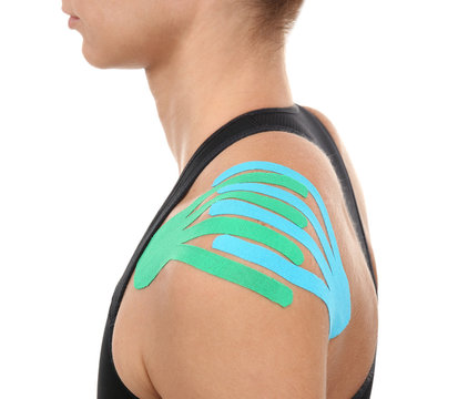 Female shoulder with physio tape on white background