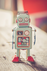 Spielzeug Blechroboter, Metapher für Social Bot / Chatbot auf Holzuntergrund